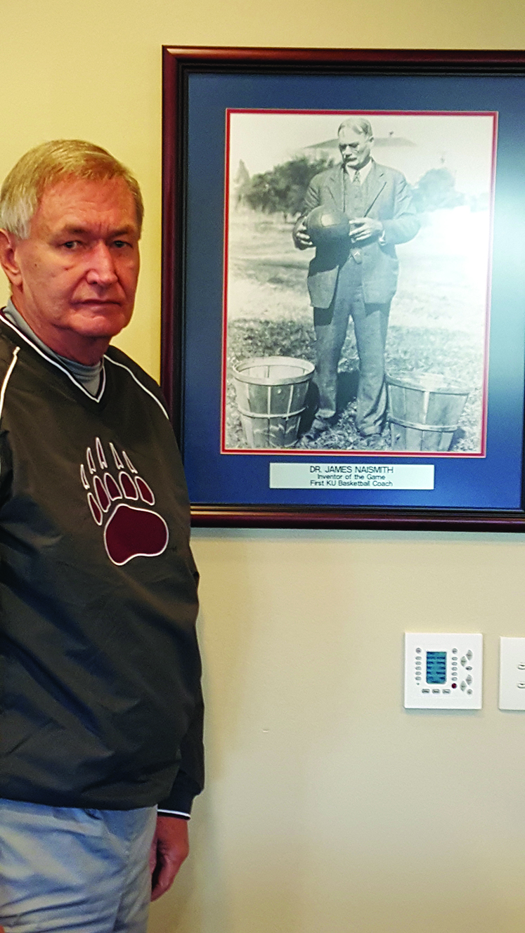 Keith Law standing next to a photo of the inventor of basketball
